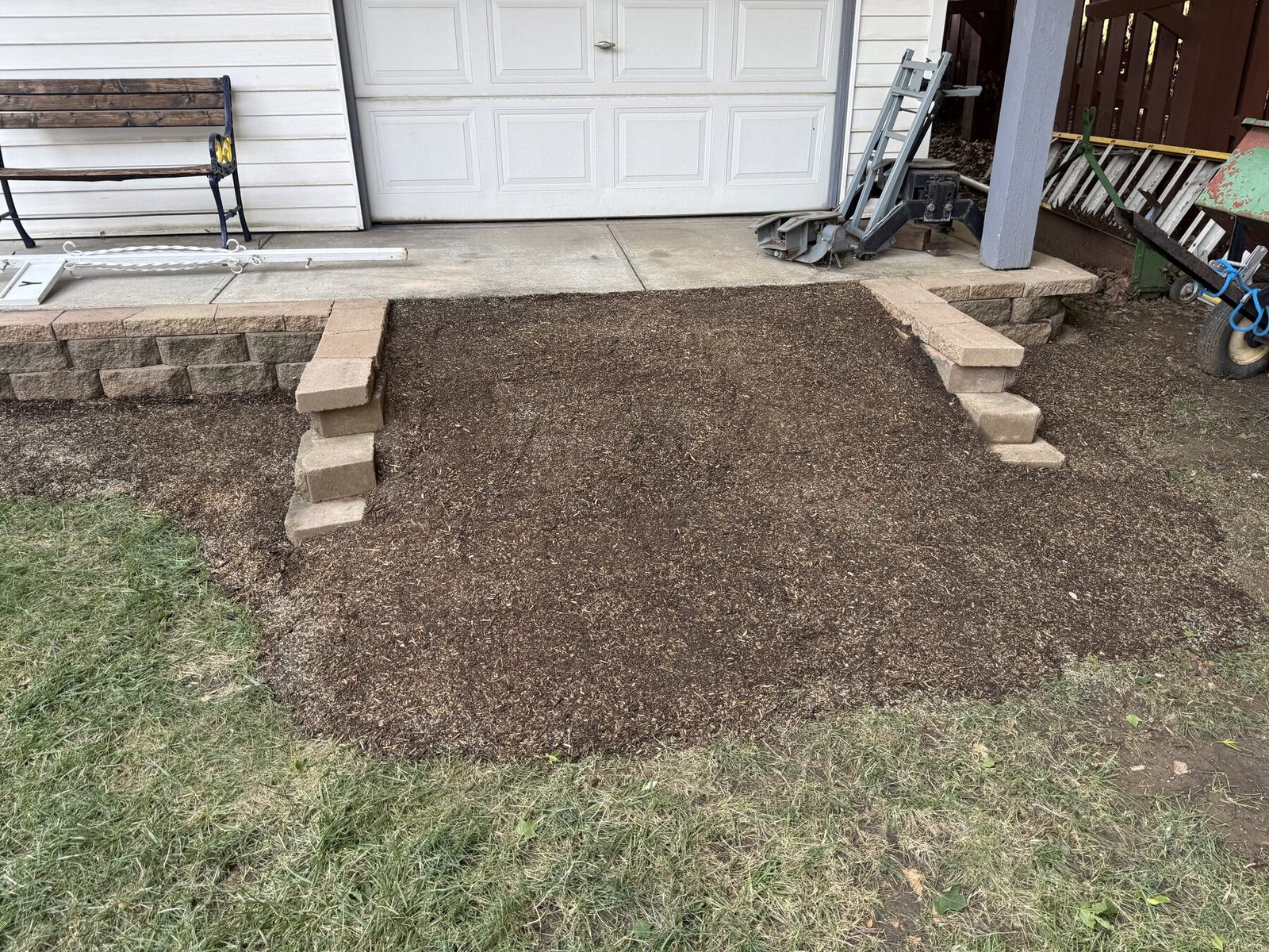 Freshly graded dirt ramp leading to a garage